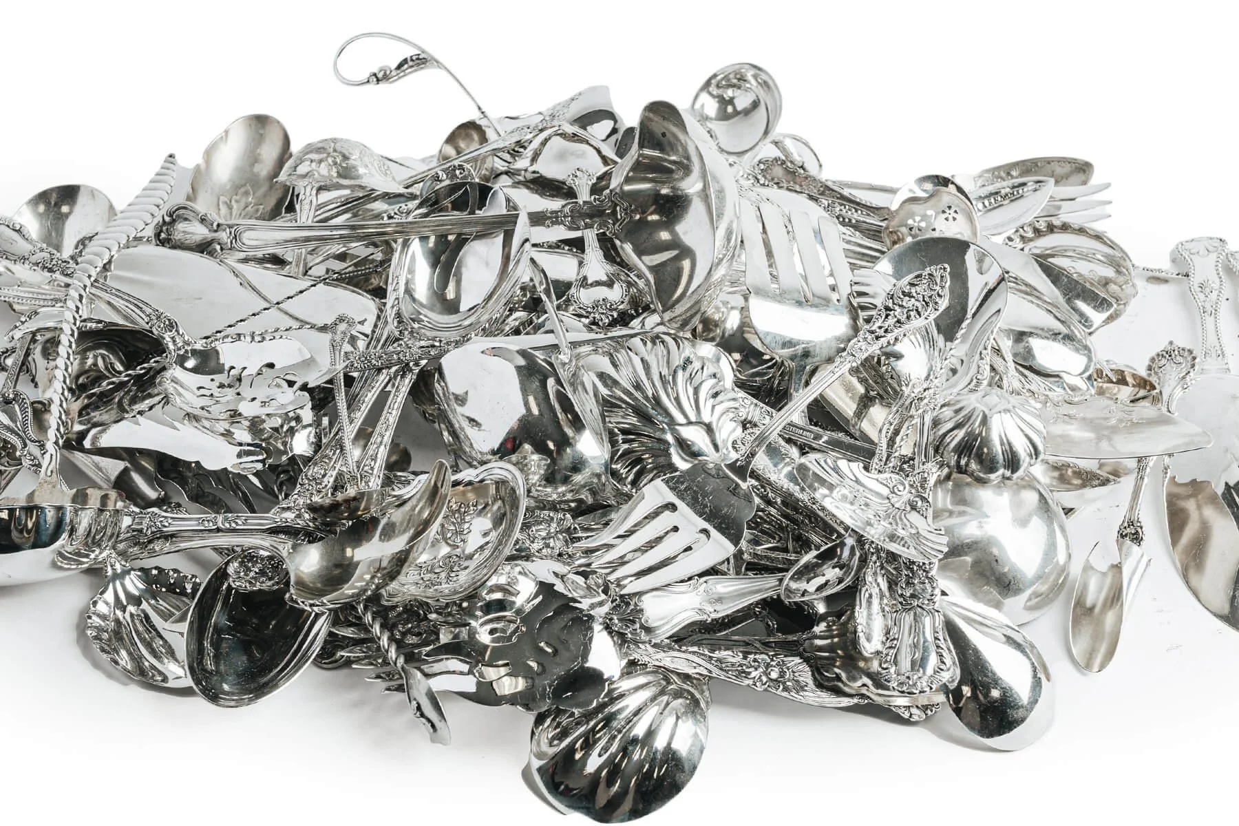 Pile of mixed scrap silver flatware including spoons, forks, ladles, and serving pieces