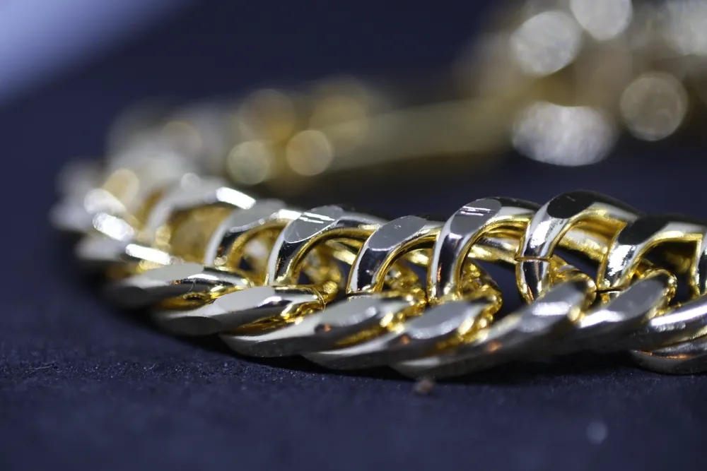 Close-up of a gold chain bracelet showcasing intricate links and a polished finish.