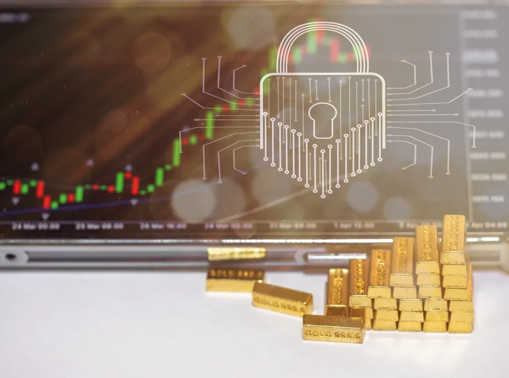 Gold bars beside a laptop secured with a padlock, symbolizing wealth and digital security.
